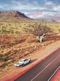 Car on road by land against sky