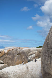 Rock formations by sea against blue sky