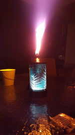 Close-up of illuminated candles against sky at night