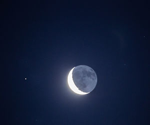 Low angle view of half moon against sky at night