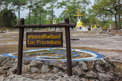 Information sign board by trees in park