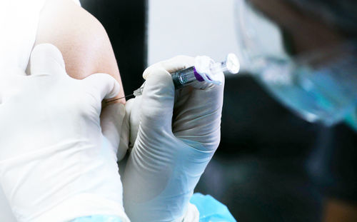 Cropped hands of doctor injecting patient