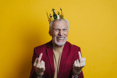 Portrait of smiling man against yellow background