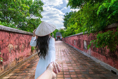 Rear view of woman standing against building
