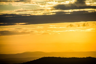 Scenic view of dramatic sky over silhouette landscape