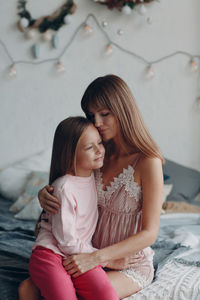 Mother and girl sitting outdoors