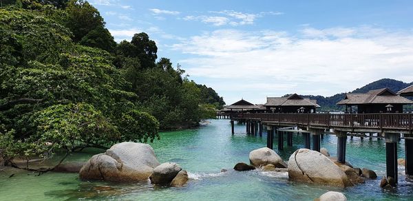 Rocks by lake against sky