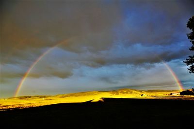 Scenic view of rainbow over mountains