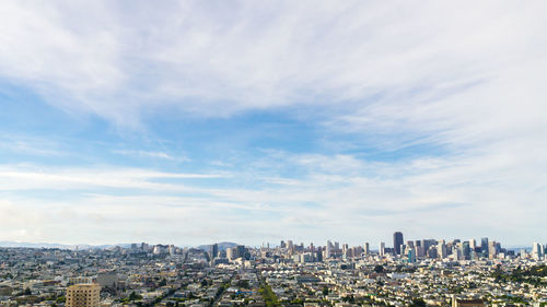 Cityscape against cloudy sky