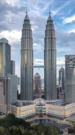 Modern buildings in city against cloudy sky