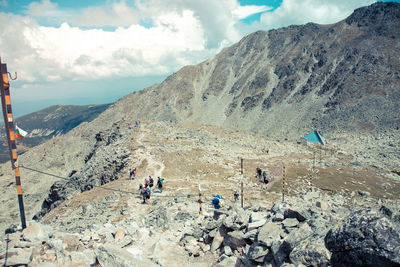 Group of people on mountain range against sky