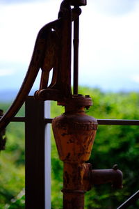 Close-up of rusty metal railing against sky