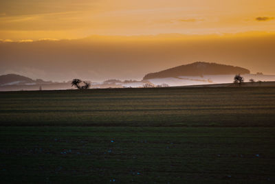 Scenic view of field against sky during sunset