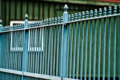 Turquoise metallic fence against building