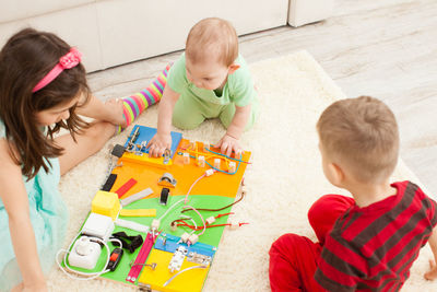 High angle view of siblings playing with toy