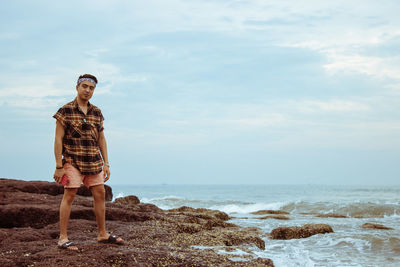 Full length of man standing at beach against sky