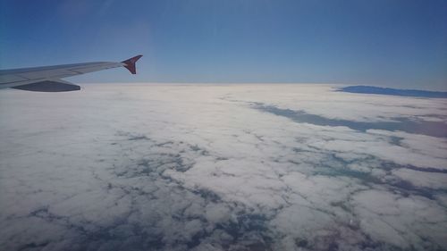 Airplane flying over cloudscape against sky