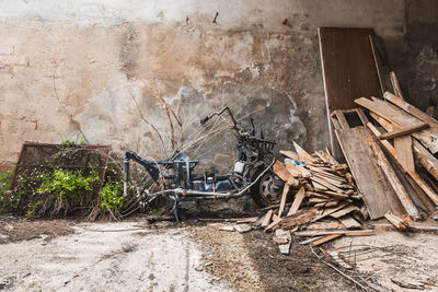 A broken old motorcycle among wooden rubble