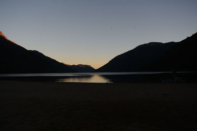 Scenic view of lake against clear sky during sunset