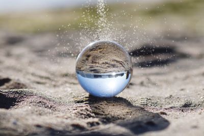 Close-up of crystal ball on beach