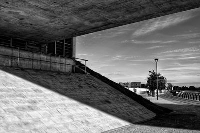 Empty footpath by building against sky