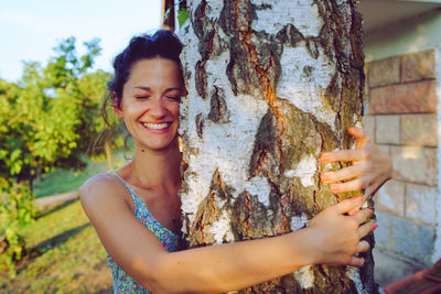 Portrait of a smiling young woman holding camera