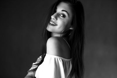 Portrait of beautiful young woman over black background