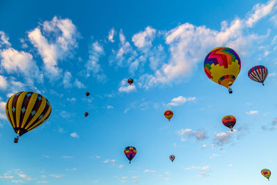 Low angle view of hot air balloons flying against sky