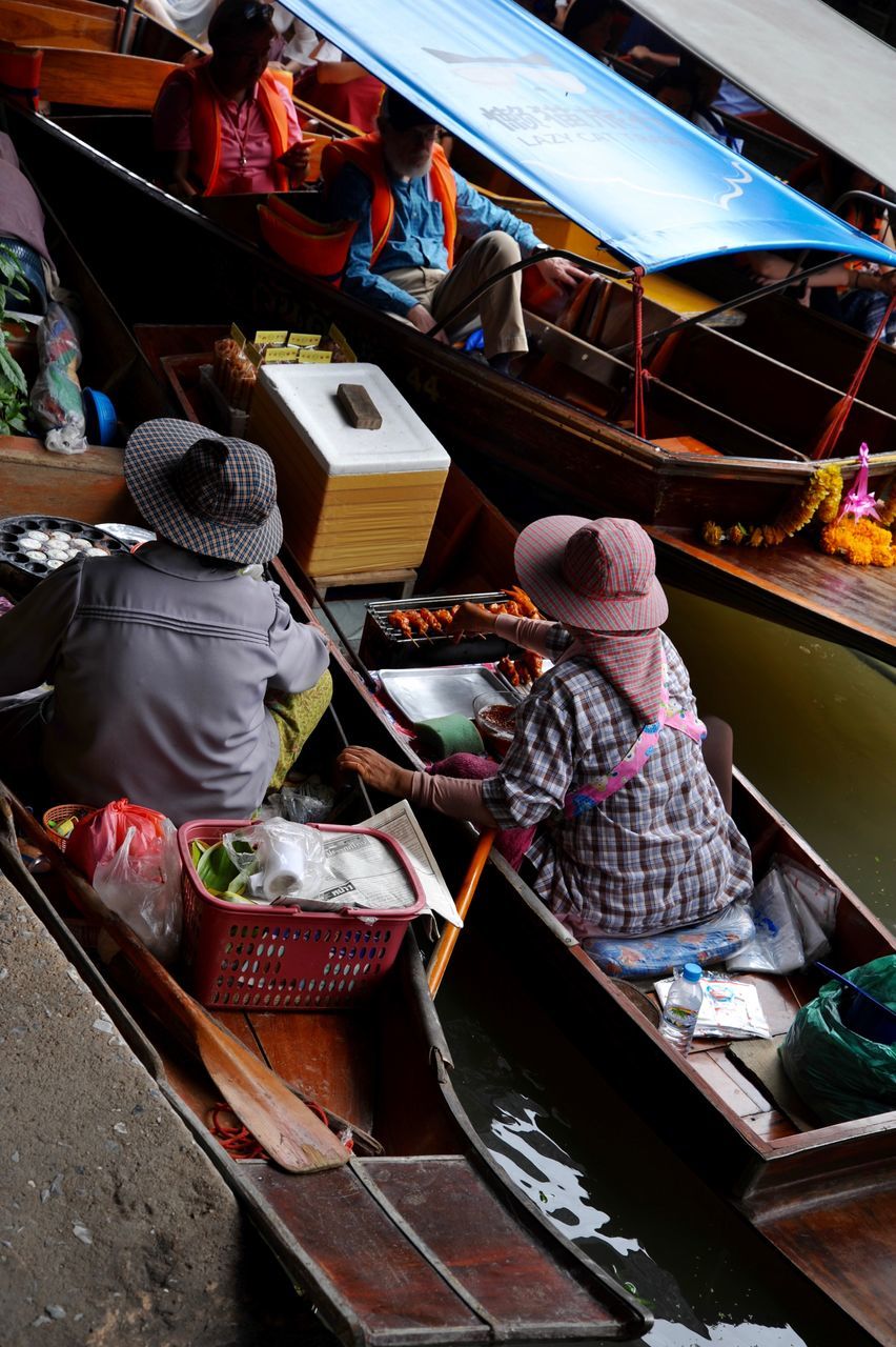 REAR VIEW OF PEOPLE SITTING IN BOAT