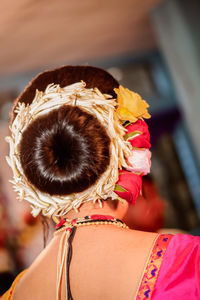 Rear view of woman wearing flowers in hair bun