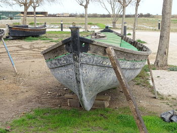 Abandoned boats moored on field