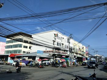 Cars on street in city against sky