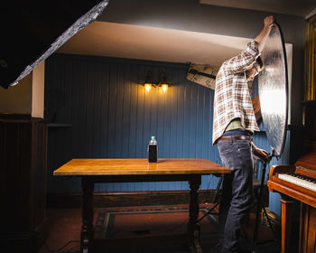 Man standing on table in restaurant