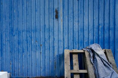 Fabric on pallet against blue fence