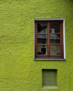 Closed window of yellow wall of house