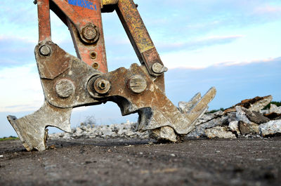 Close-up of rusty machine part against sky