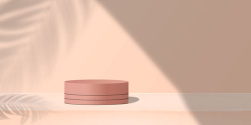 Close-up of lamp on table against wall