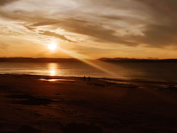 Scenic view of beach against sky during sunset