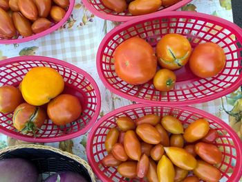 Above view of baskets of vegetables on table in vendor's booth at local farmer's market