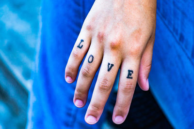 Cropped image of hand with love text tattoo