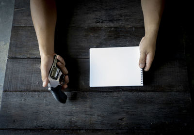 High angle view of woman using smart phone on table