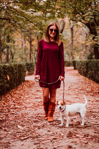 Portrait of woman with dog walking in park