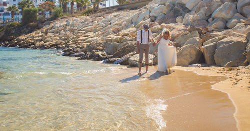 Woman standing on beach by sea