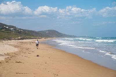 Full length of woman on beach against sky