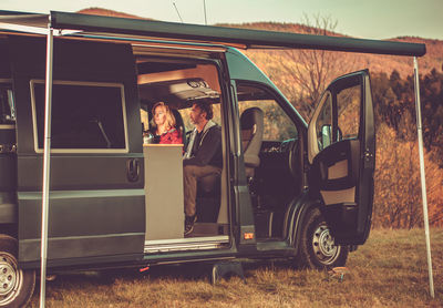 Couple watching tv while sitting at motor home