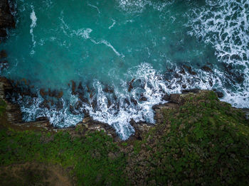 High angle view of waves splashing on rocks