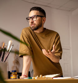 Young man looking away while sitting at home