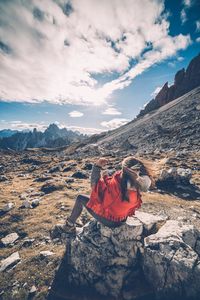 Man climbing on mountain against sky