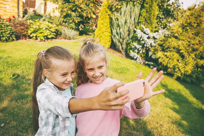 Cute girls taking selfie while standing outdoors