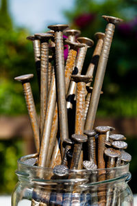 Close-up of rusty screws in jar on table